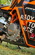 Close-up of a dirt bike engine with 'KTM' branding on a grassy background